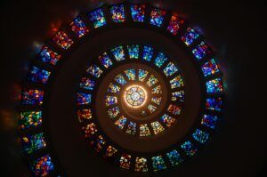 Captivating spiral stained glass art with vibrant colors forming a dramatic eye-catching pattern.